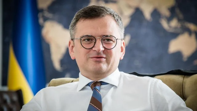 Олексій Кулеба на тлі карти світу та прапора України