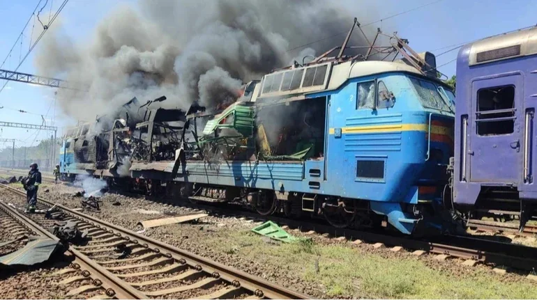 Пошкоджений синій локомотив електропотяга з густим чорним димом після подвійного удару Росії по потягу в Запорізькій області.