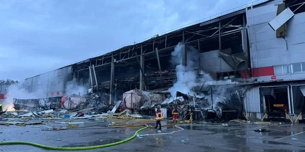 Зруйнований термінал з димом, уламками та рятувальниками на передньому плані